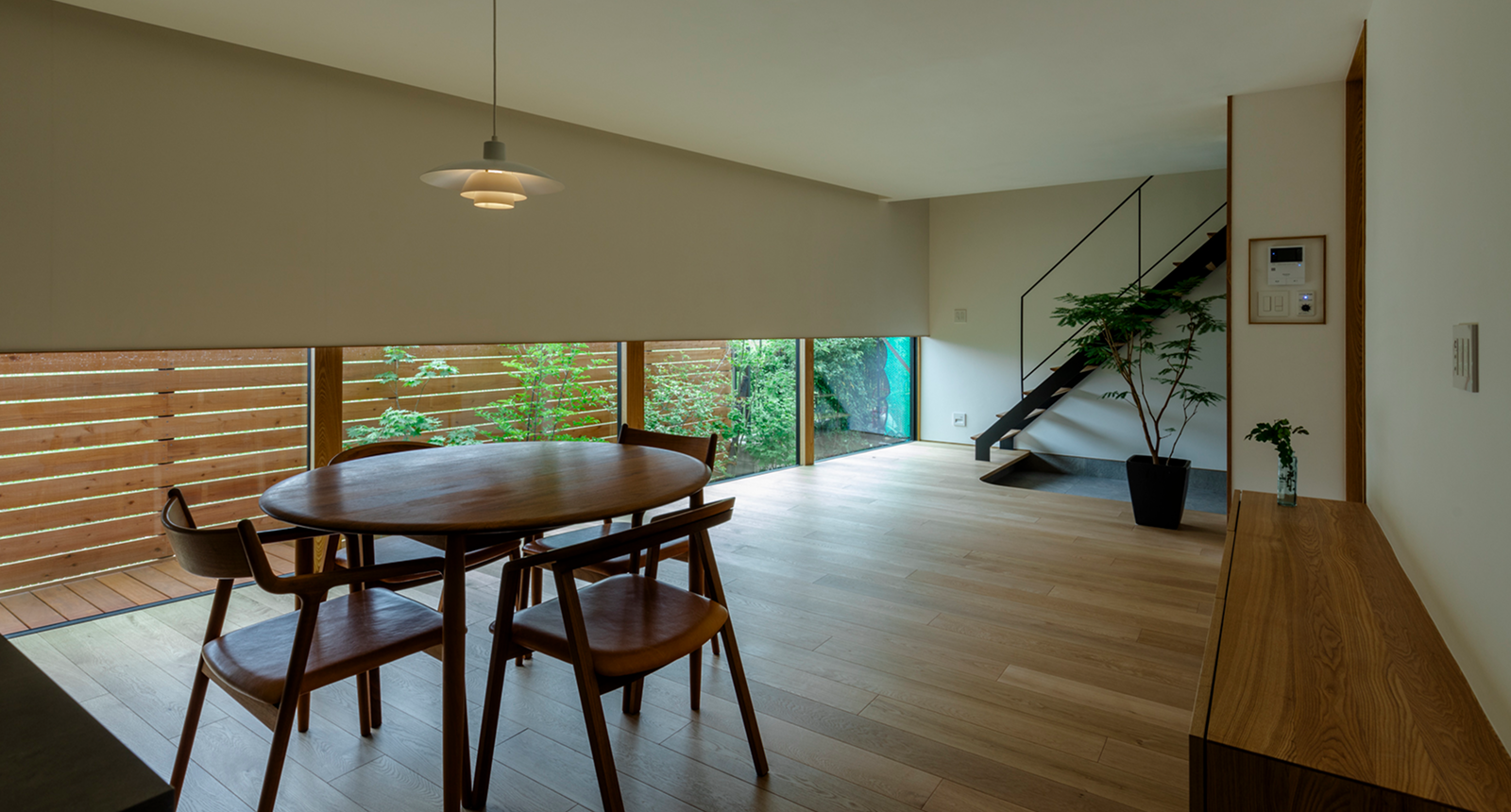 地窓に緑を映す家